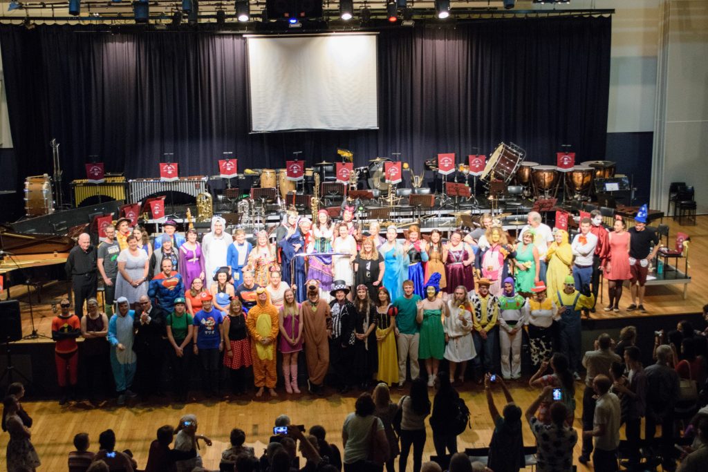 The Musicians of QWAB stand at the front of a stage dressed up as characters from Animation